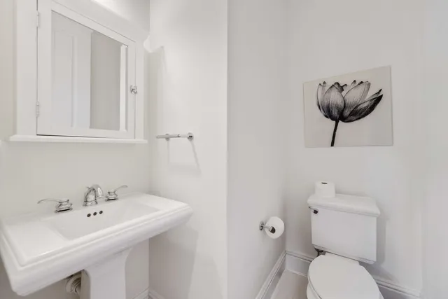 a bathroom with a toilet a sink and a mirror