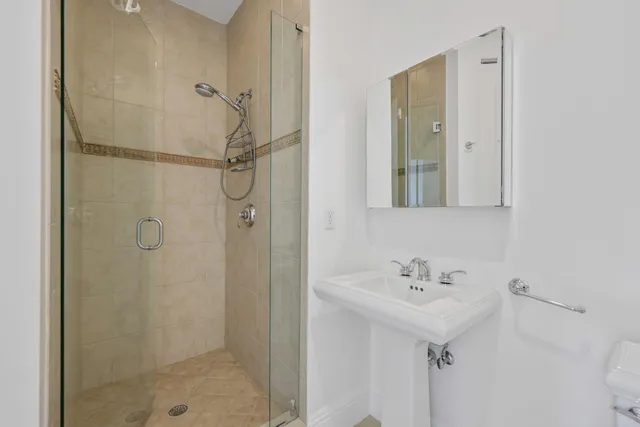 a bathroom with a shower sink and mirror