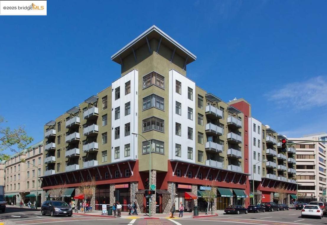 a front view of a building with lot of cars and trees