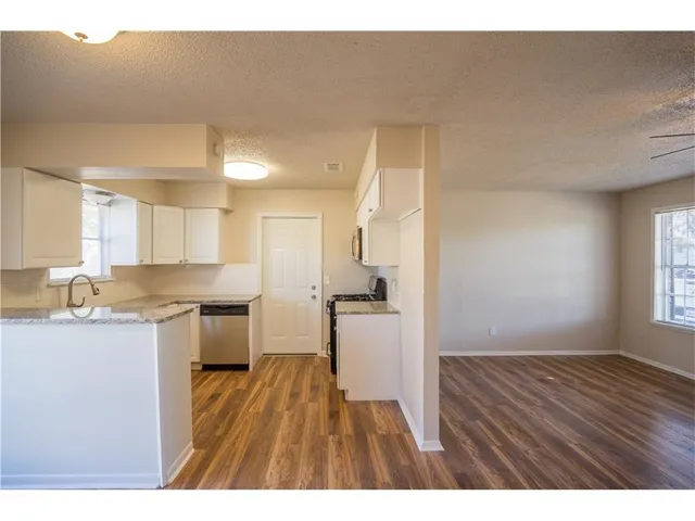 a open kitchen with a sink and wooden floor