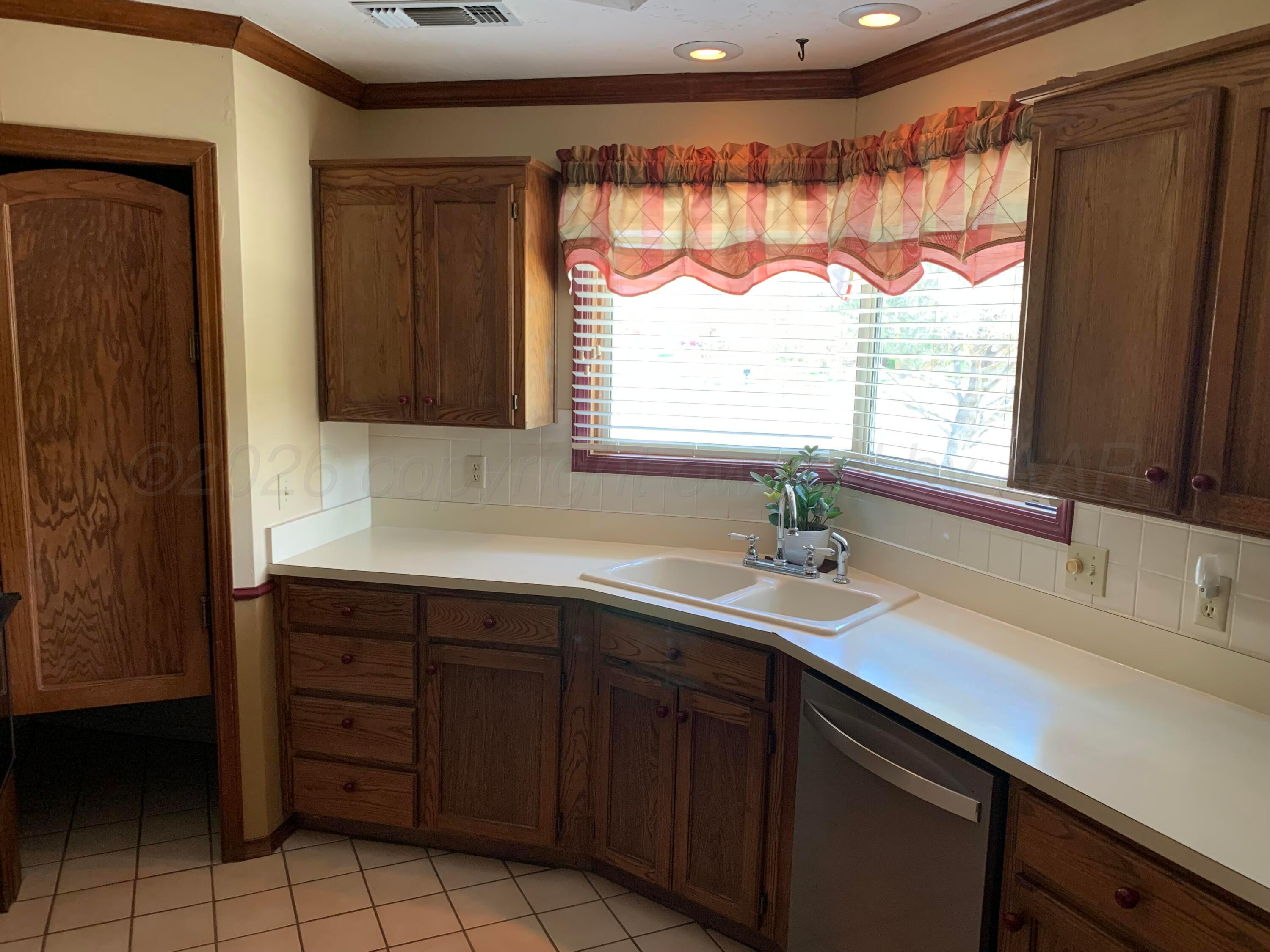 6101 Ridgewood Drive Amarillo, TX 79109 - Photo 11 of 28 a sink with a large window and cabinets
