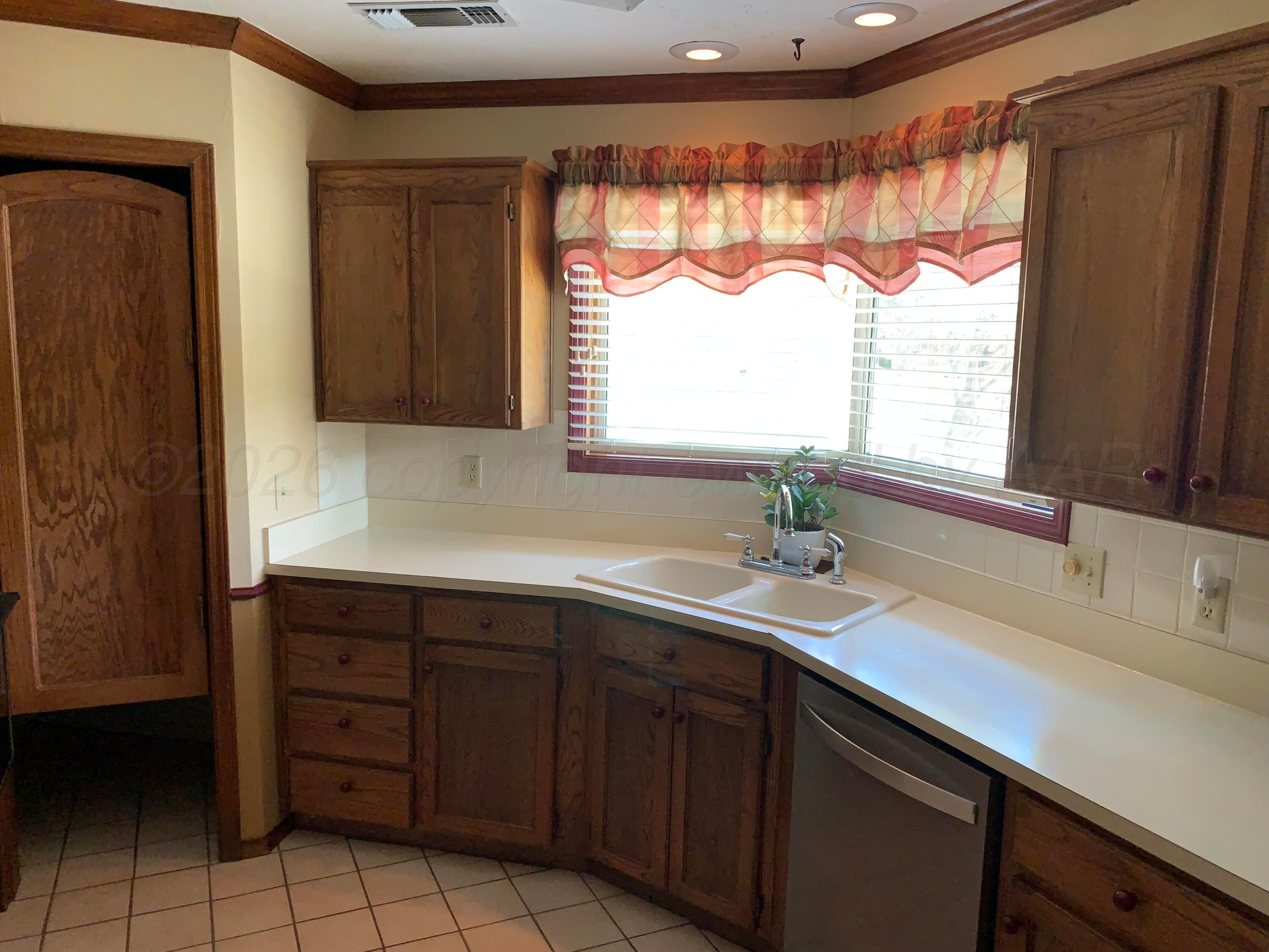 6101 Ridgewood Drive Amarillo, TX 79109 - Photo 8 of 28 a sink with a large window and cabinets