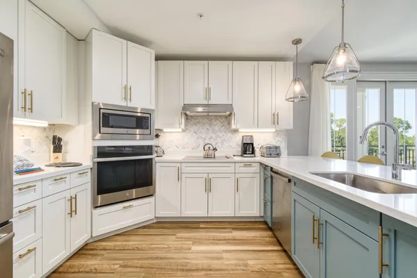 a kitchen with cabinets stainless steel appliances and wooden floor