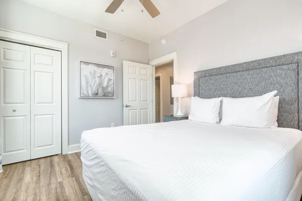 a bedroom with a large bed and a flat tv screen on dresser