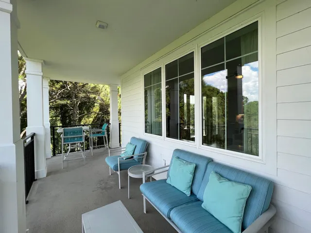 a balcony with furniture and large windows