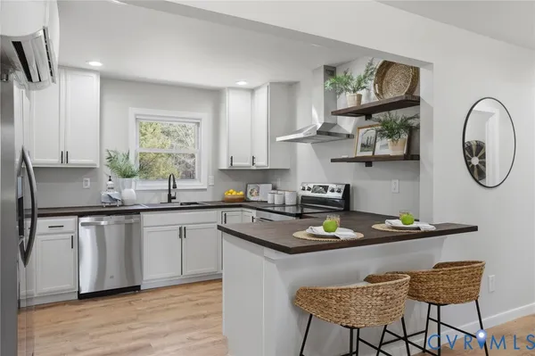 a kitchen with stainless steel appliances granite countertop a sink a stove and a refrigerator