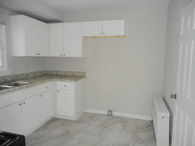 a view of a kitchen with white cabinets