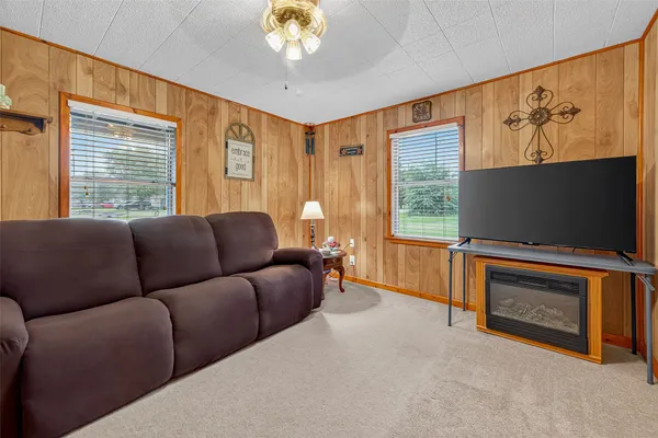 a living room with furniture a flat screen tv and a fireplace