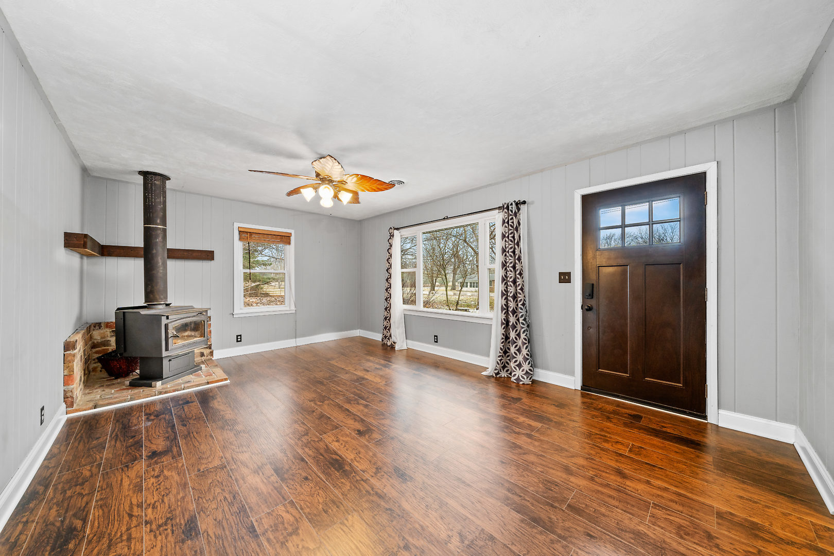 86 Bristol Ridge Road Bristol, IL 60512 - Photo 6 of 41 an empty room with wooden floor a ceiling fan and windows