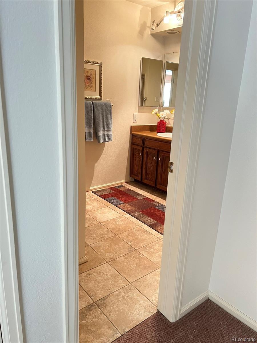 8488 Everett Way, Unit A Arvada, CO 80005 - Photo 14 of 27 a en suite bathroom with a sink and mirror