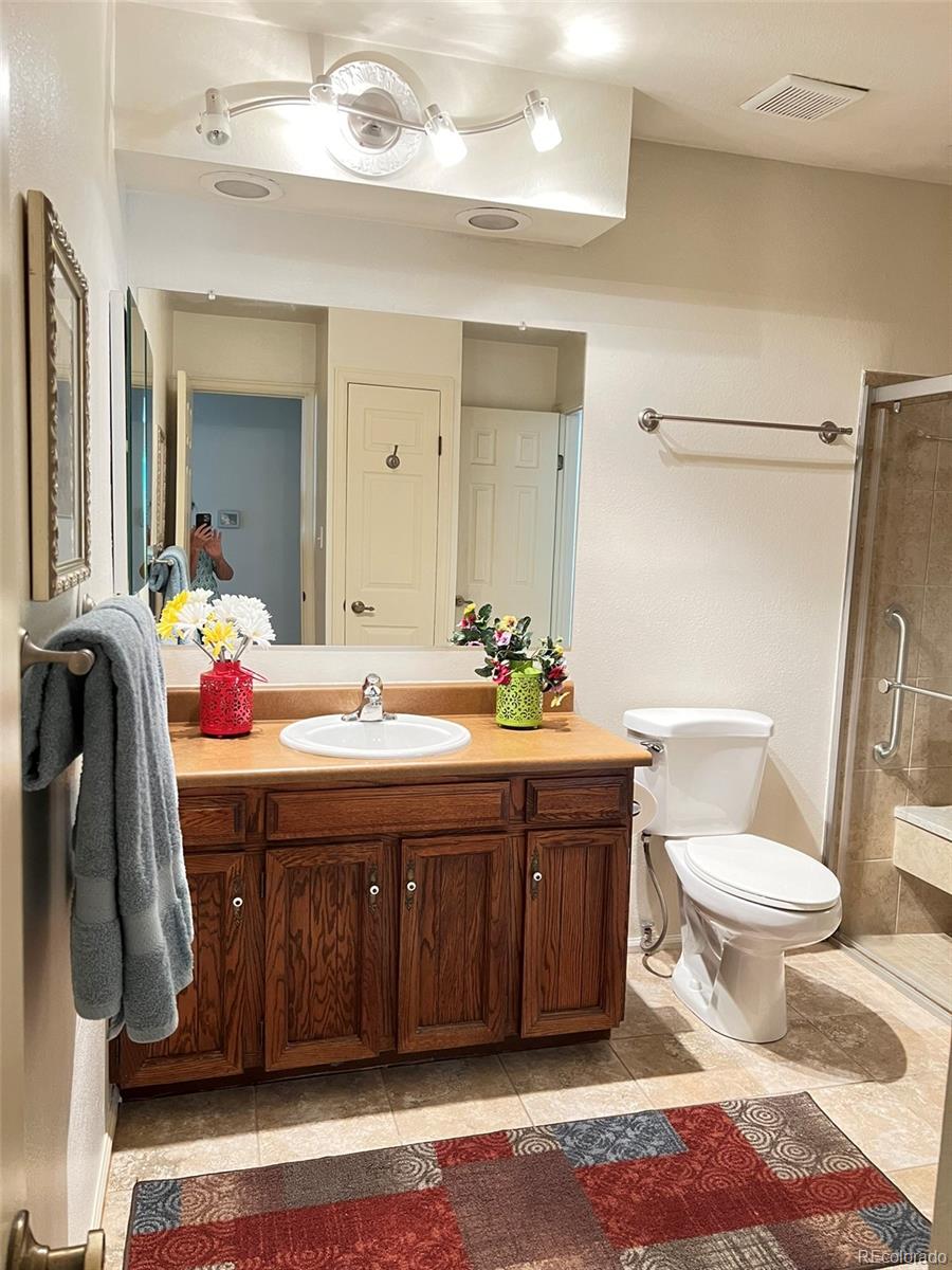 8488 Everett Way, Unit A Arvada, CO 80005 - Photo 15 of 27 a bathroom with a sink vanity mirror and toilet