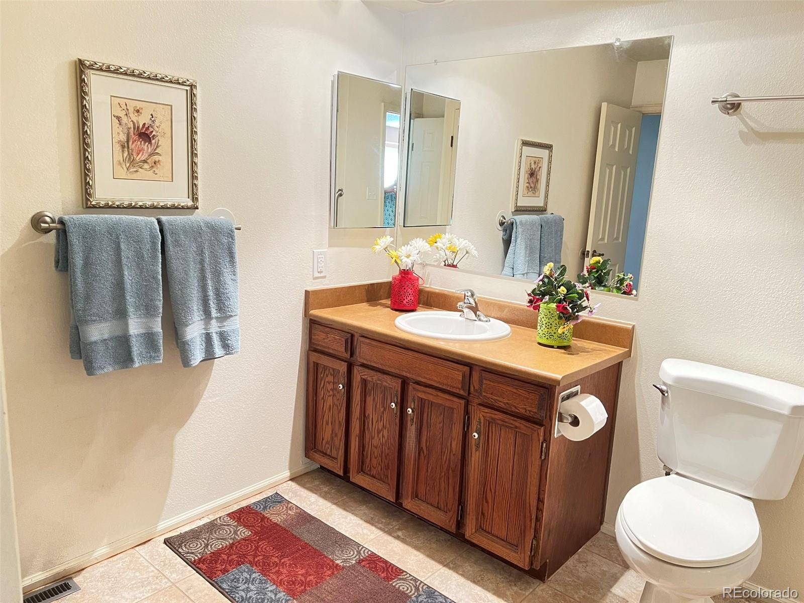 8488 Everett Way, Unit A Arvada, CO 80005 - Photo 16 of 27 a bathroom with a sink vanity mirror and toilet
