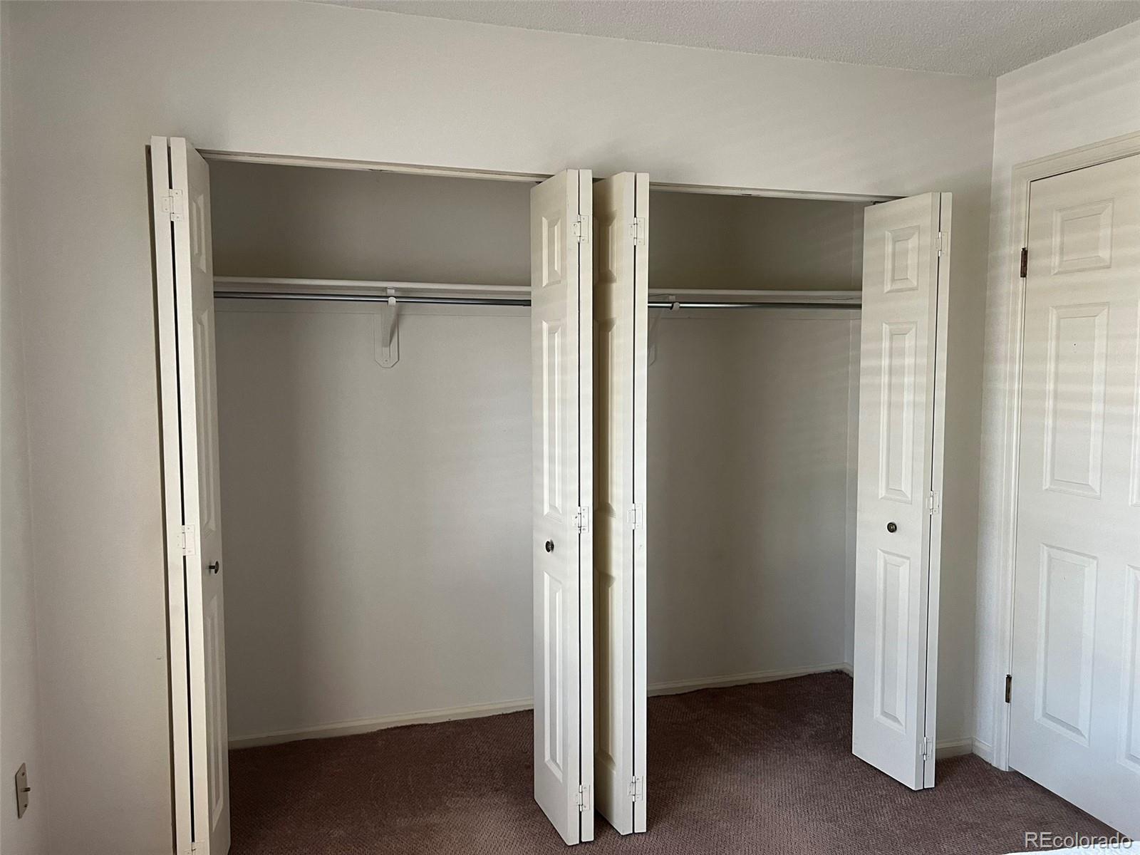 8488 Everett Way, Unit A Arvada, CO 80005 - Photo 21 of 27 a view of walk in closet with empty racks