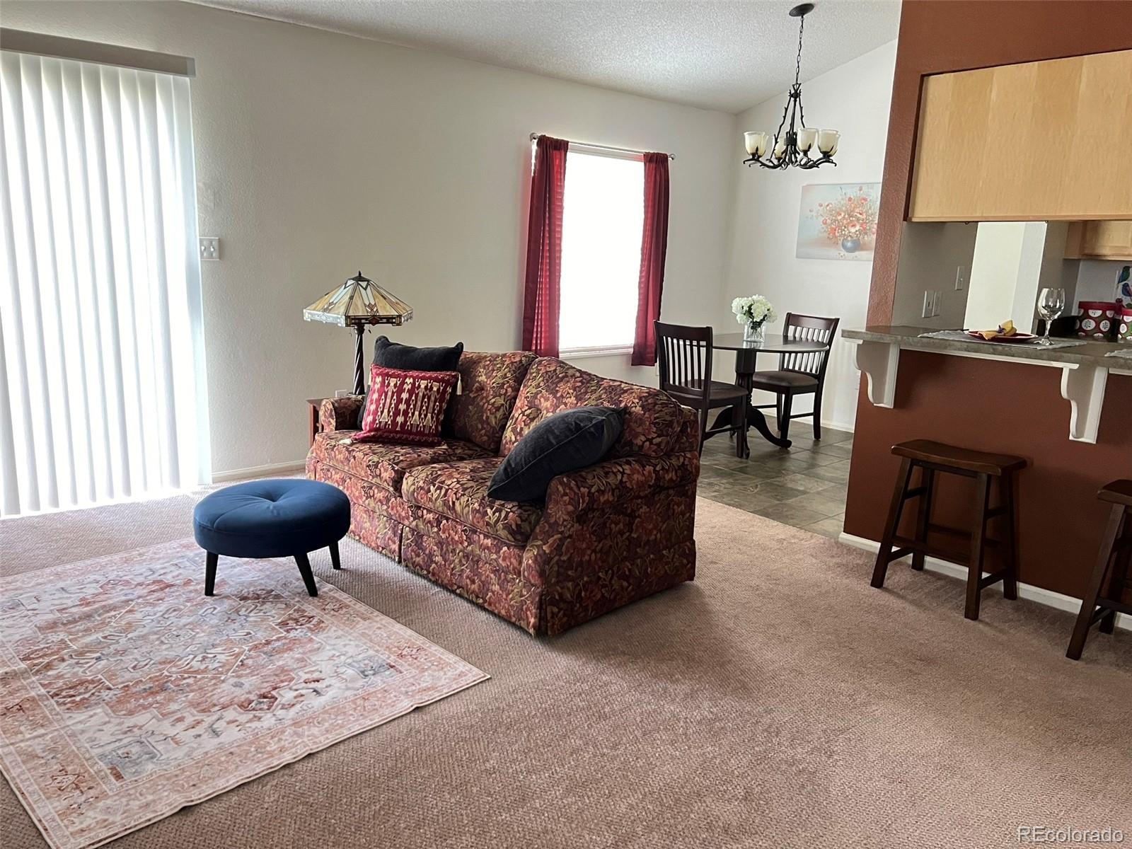 8488 Everett Way, Unit A Arvada, CO 80005 - Photo 3 of 27 a living room with furniture a table and a large window