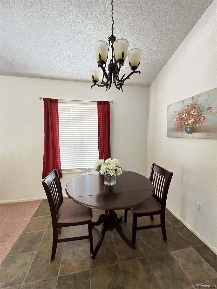 8488 Everett Way, Unit A Arvada, CO 80005 - Photo 5 of 27 a view of a dining room with furniture wooden floor and a chandelier