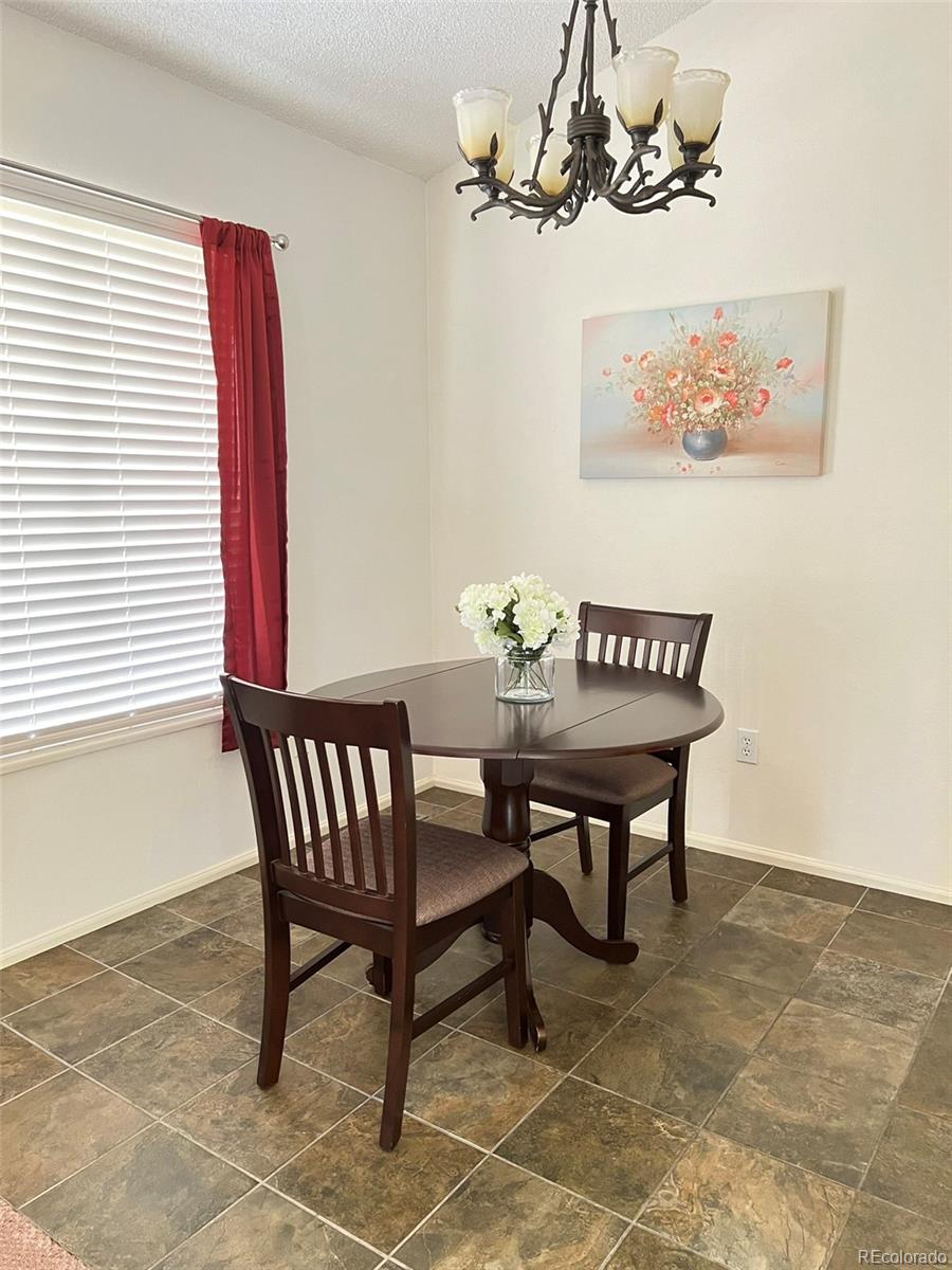 8488 Everett Way, Unit A Arvada, CO 80005 - Photo 6 of 27 a view of a dining room with furniture and chandelier