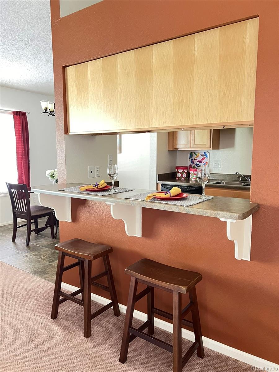 8488 Everett Way, Unit A Arvada, CO 80005 - Photo 10 of 27 a room with a table chairs and a kitchen view
