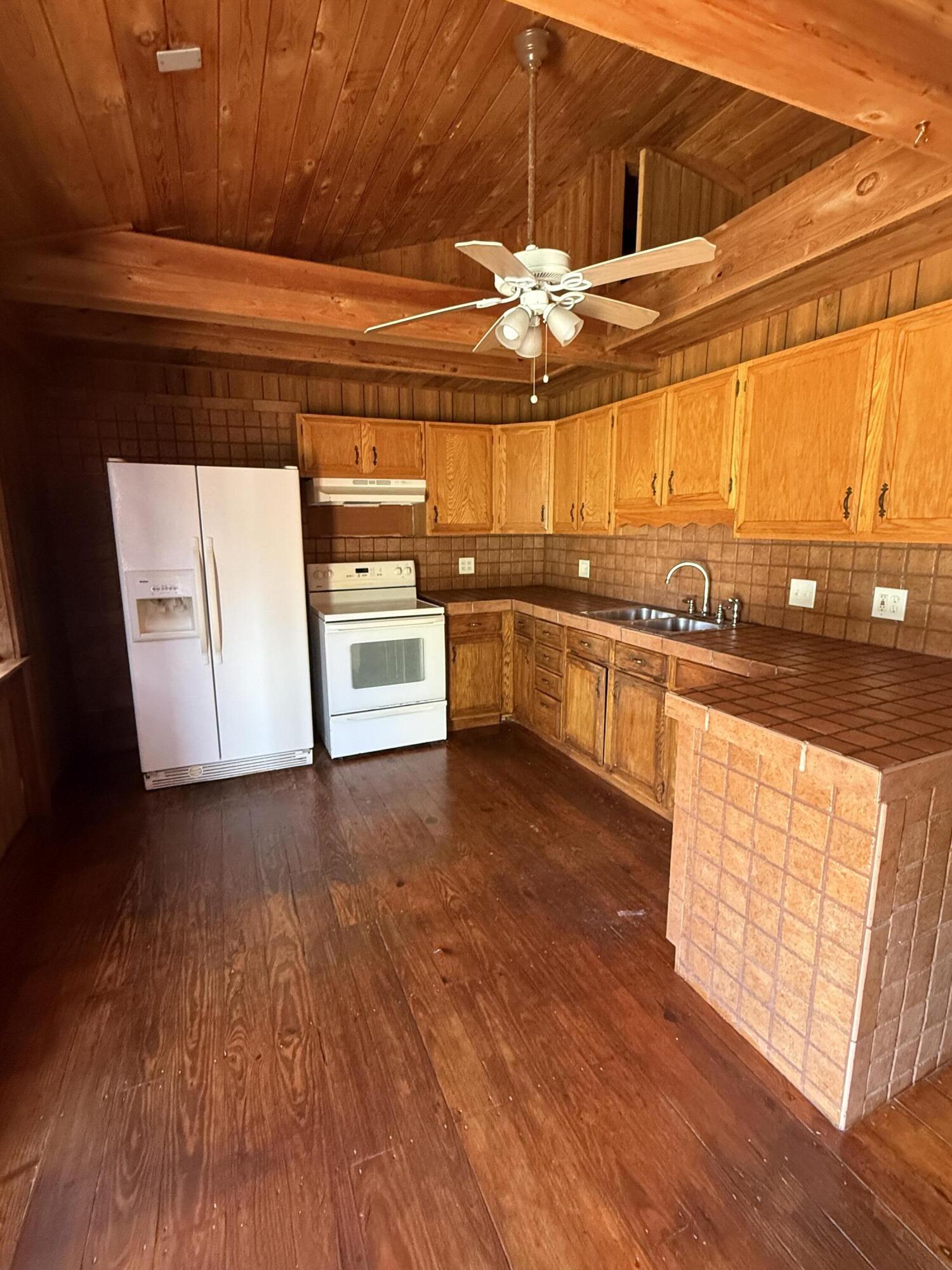 3611 Elizabeth Street Palm Springs, FL 33461 - Photo 4 of 19 a kitchen with stainless steel appliances a stove a sink and white cabinets with wooden floor