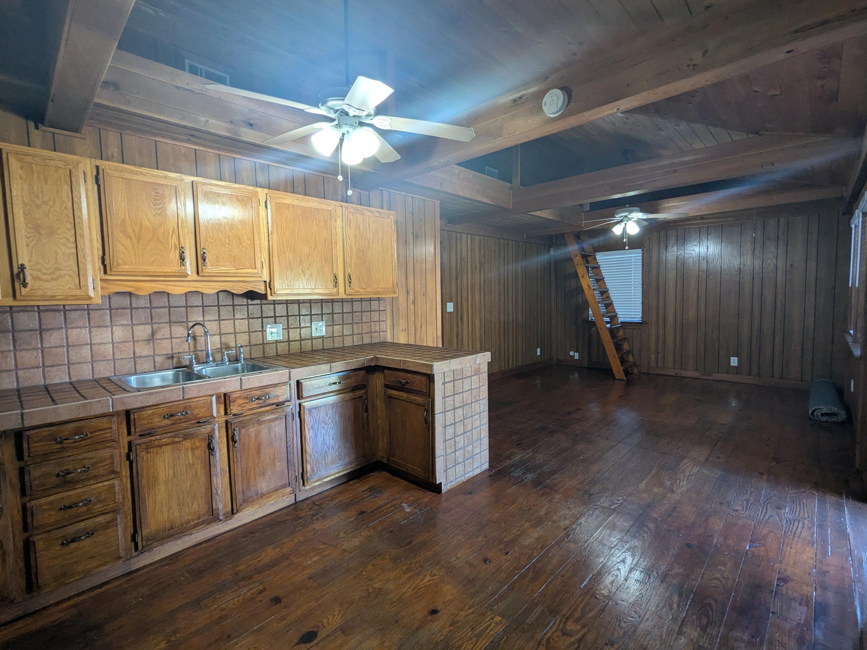 3611 Elizabeth Street Palm Springs, FL 33461 - Photo 6 of 19 a kitchen with kitchen island granite countertop a sink cabinets and wooden floor