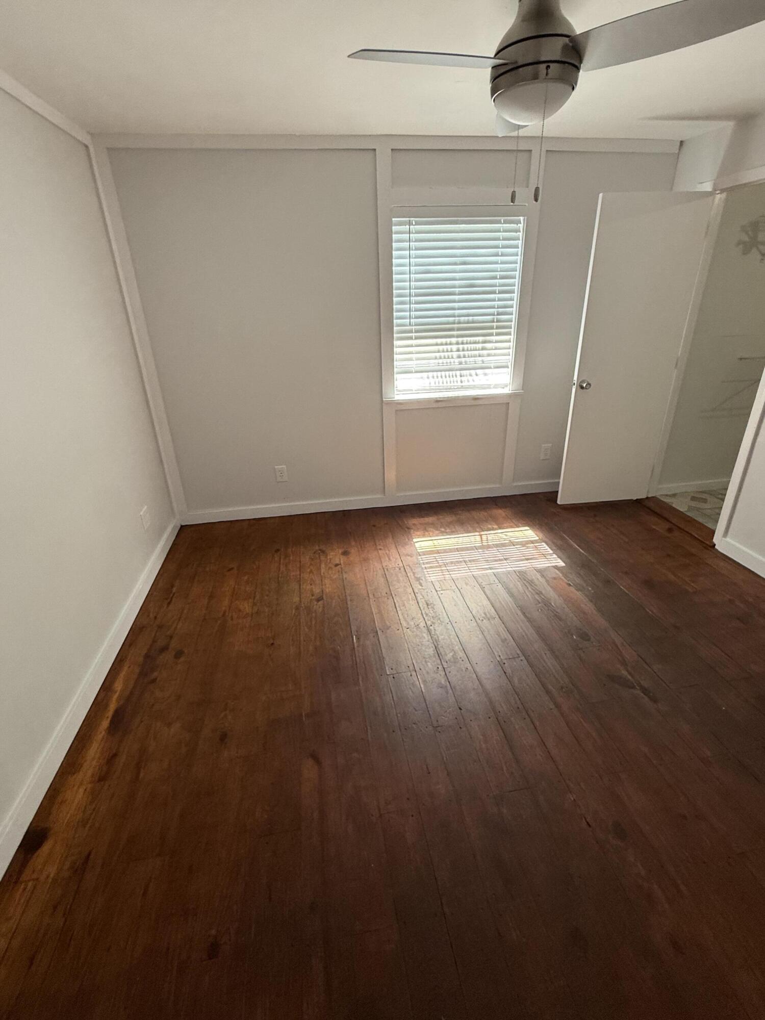 3611 Elizabeth Street Palm Springs, FL 33461 - Photo 8 of 19 an empty room with wooden floor and windows