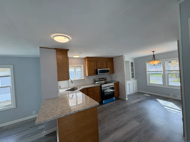 a kitchen with granite countertop a stove top oven sink and cabinets