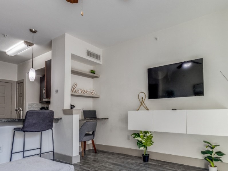 145 Heights Boulevard, Unit 229 Houston, TX 77007 - Photo 3 of 12 a living room with furniture and a flat screen tv