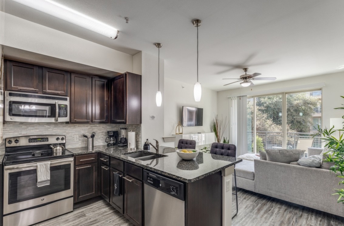 145 Heights Boulevard, Unit 229 Houston, TX 77007 - Photo 5 of 12 a kitchen with stainless steel appliances granite countertop a sink stove and refrigerator