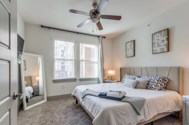a bedroom with a bed and a ceiling fan