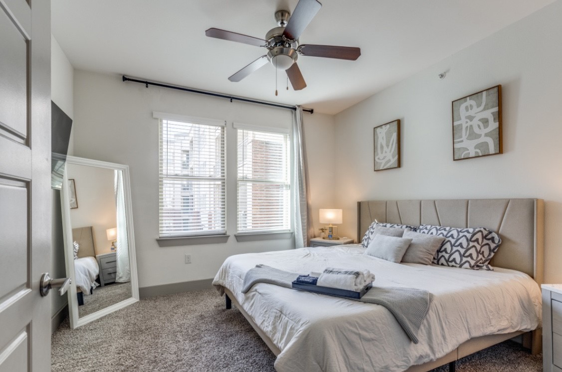 145 Heights Boulevard, Unit 229 Houston, TX 77007 - Photo 6 of 12 a bedroom with a bed and a ceiling fan
