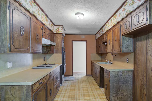 a kitchen with stainless steel appliances granite countertop a sink stove and cabinets