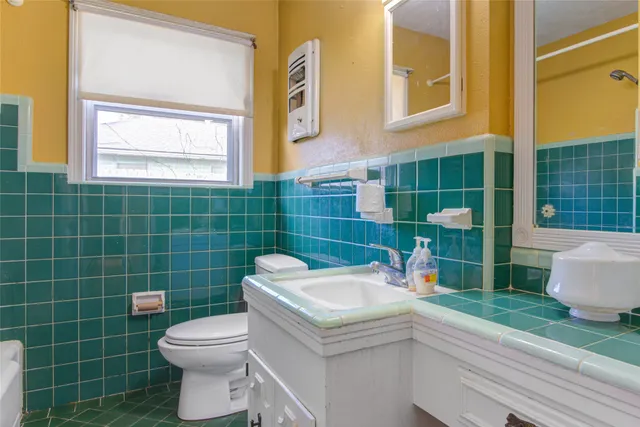 a bathroom with a sink a toilet and a mirror