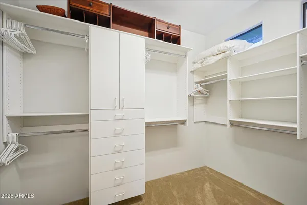 a view of walk in closet with empty racks
