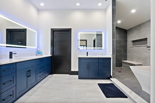 a spacious bathroom with a double vanity sink a large mirror and a bathtub