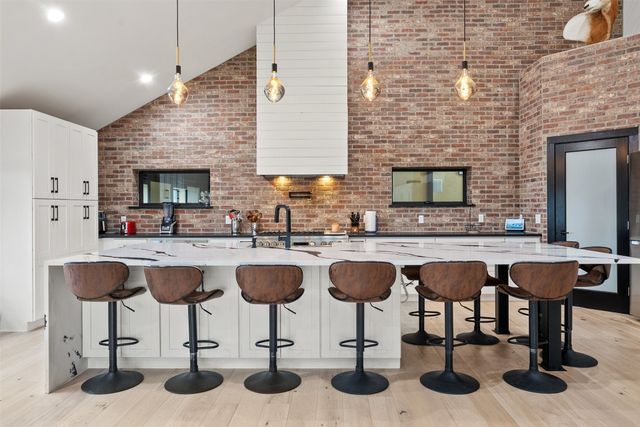 a kitchen with a granite countertop sink and chairs