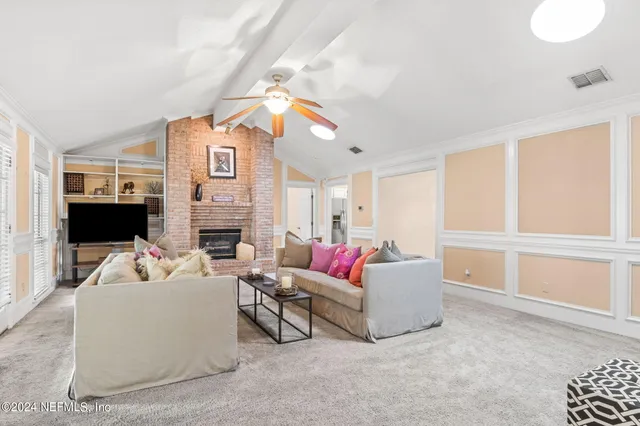 a living room with furniture a fireplace and a flat screen tv