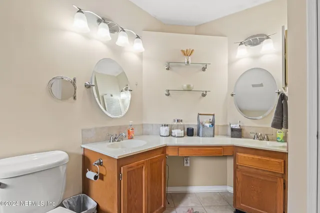 a bathroom with a double vanity sink mirror and toilet