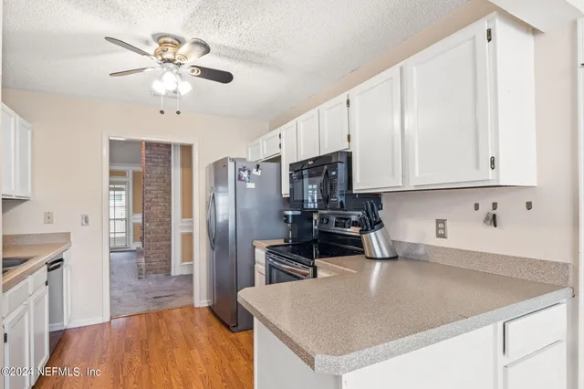 a kitchen with stainless steel appliances granite countertop a sink a stove cabinets and wooden floor