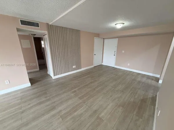 an empty room with wooden floor and closet