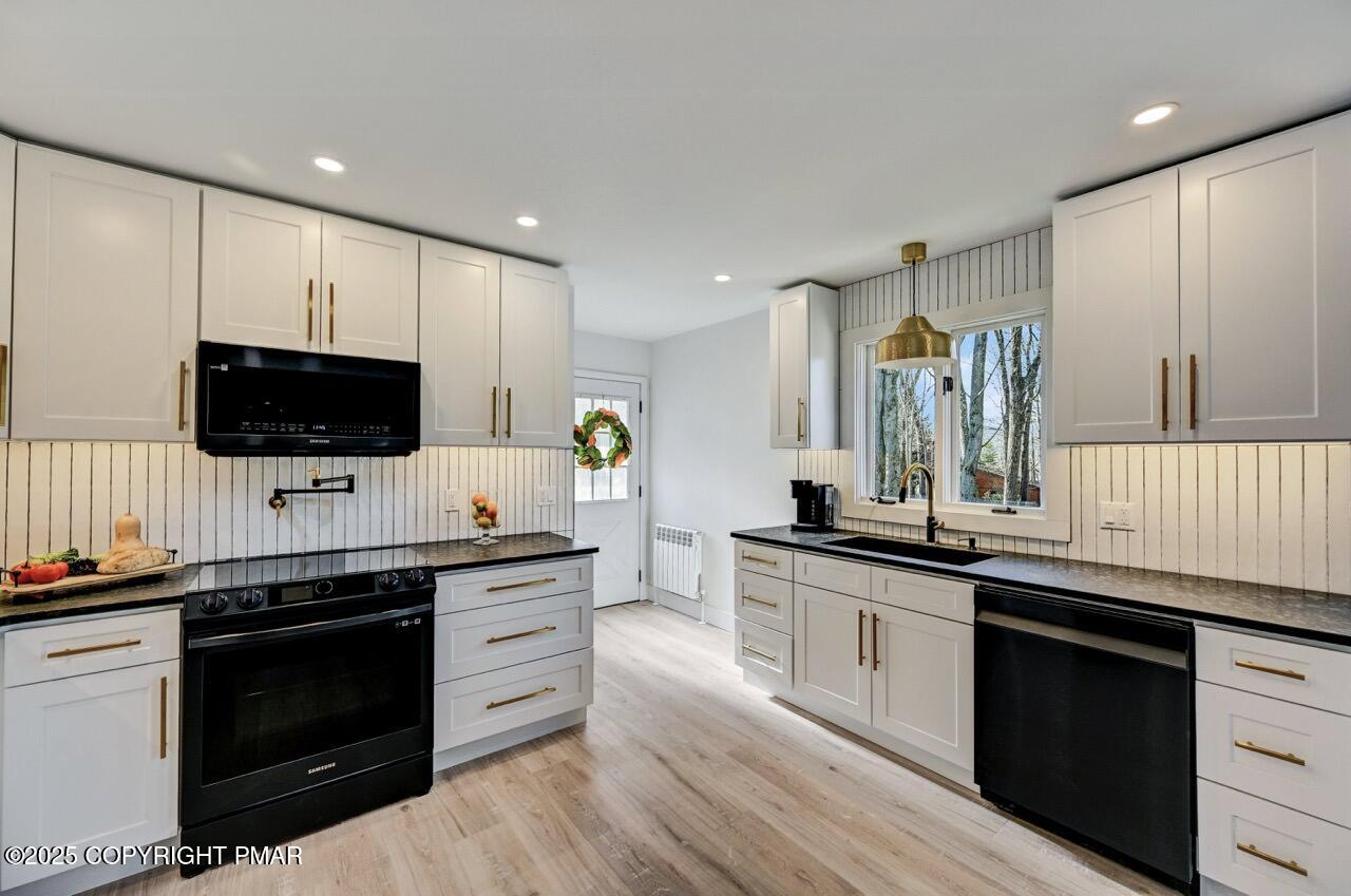 205 Winona Road Mount Pocono, PA 18344 - Photo 12 of 47 a kitchen with stainless steel appliances a sink dishwasher a stove and a microwave oven with wooden floor