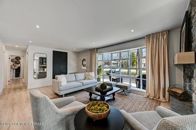 a open dining room with furniture wooden floor kitchen view and a chandelier