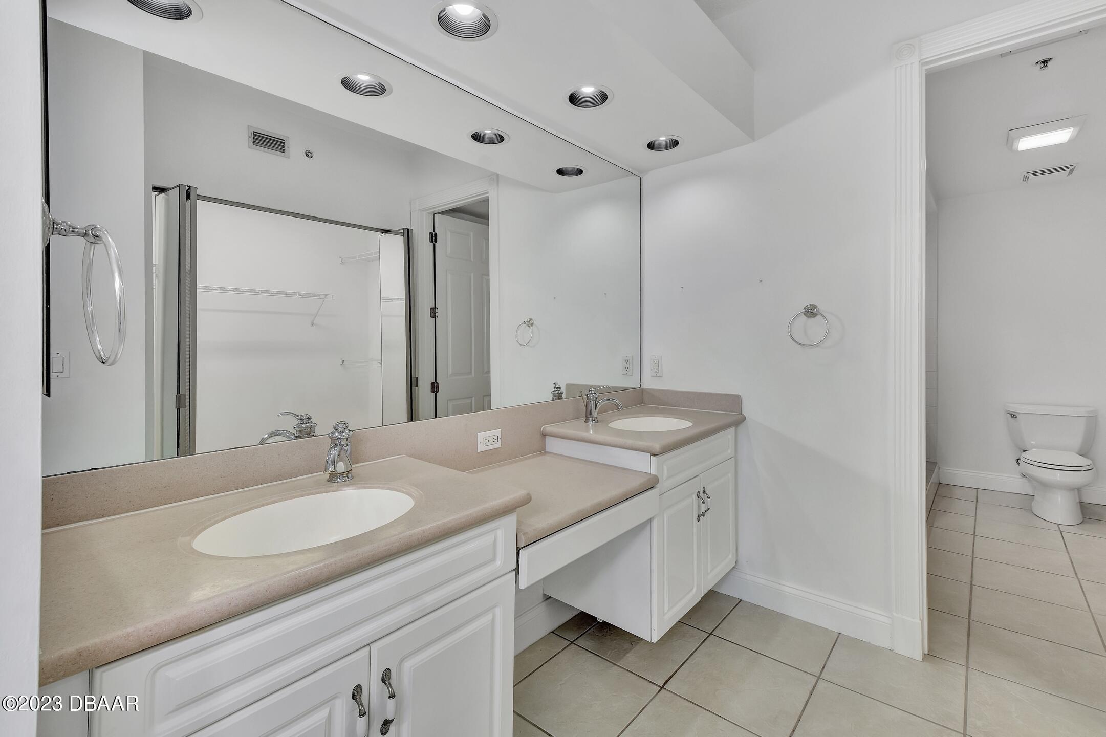 4623 Rivers Edge Village Lane, Unit 6308 Ponce Inlet, FL 32127 - Photo 21 of 55 a bathroom with a granite countertop sink a mirror and a toilet