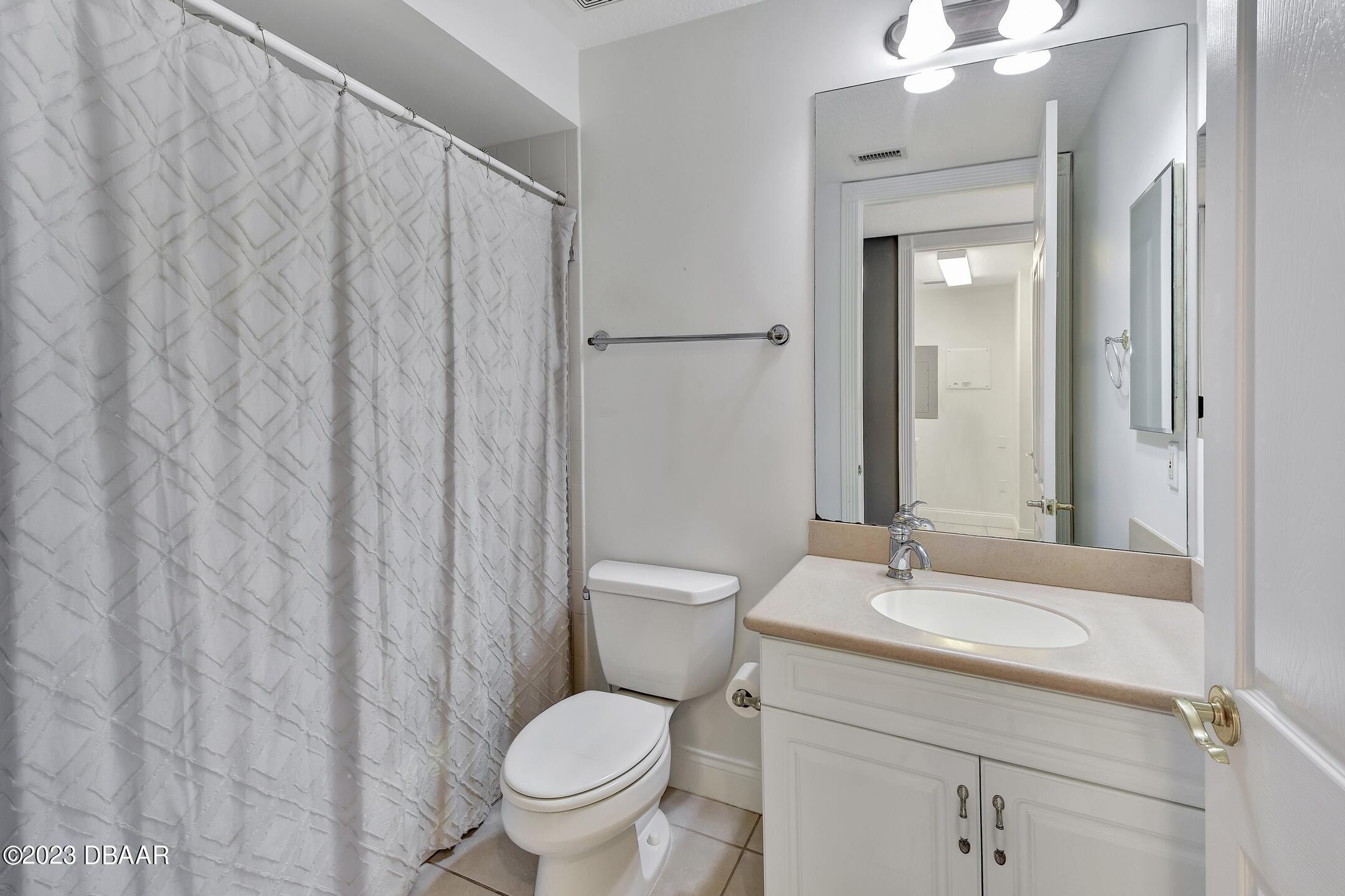 4623 Rivers Edge Village Lane, Unit 6308 Ponce Inlet, FL 32127 - Photo 25 of 55 a bathroom with a toilet a sink and a mirror