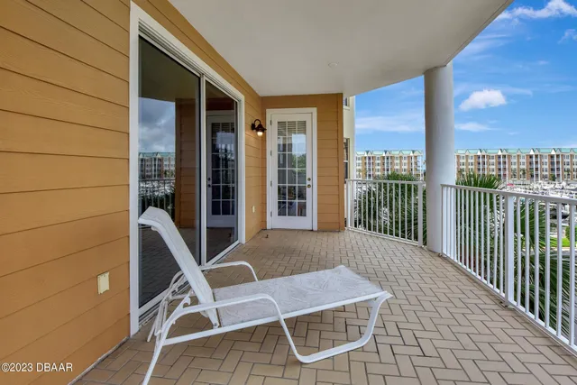 a view of a refrigerator in kitchen and an empty room