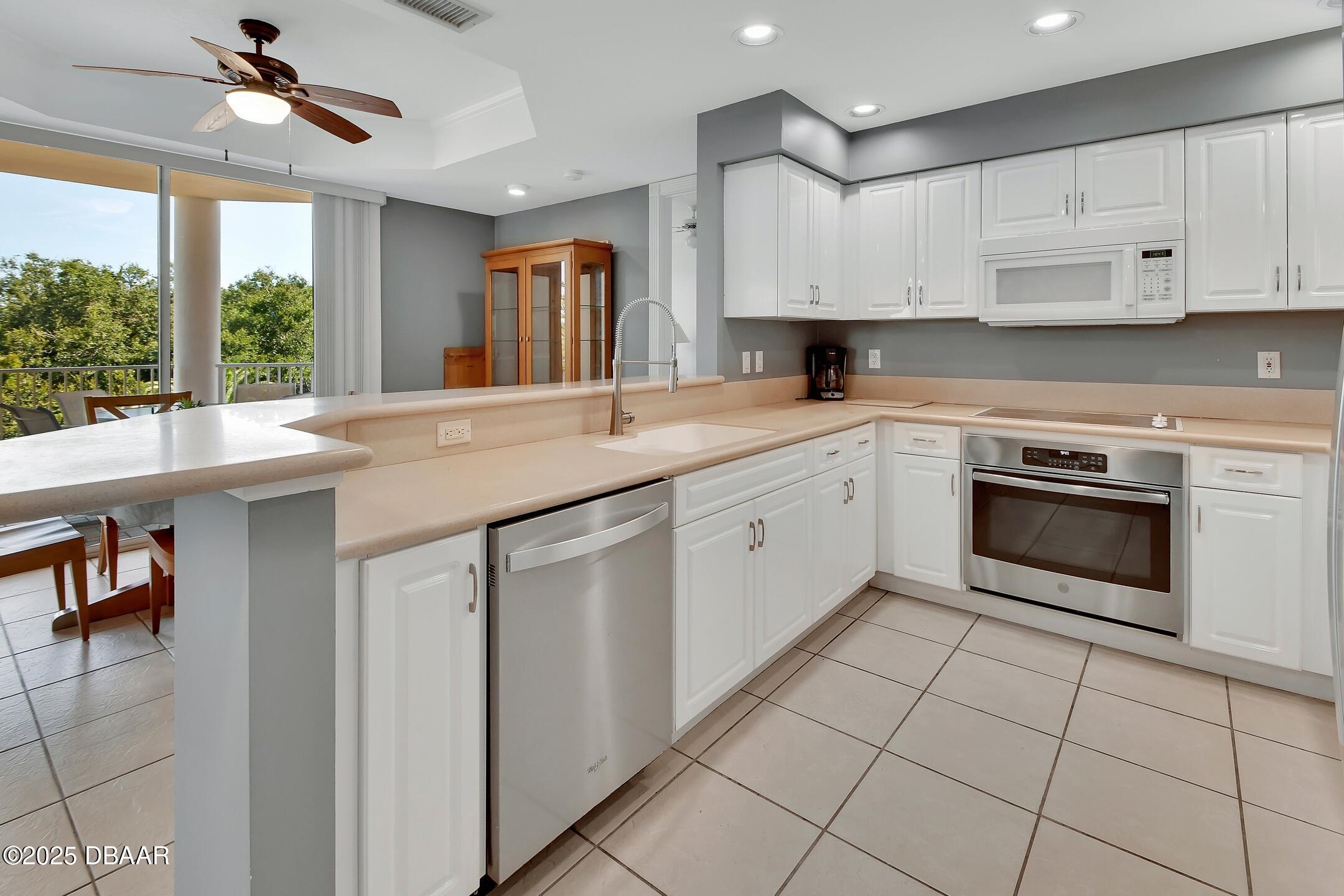 4623 Rivers Edge Village Lane, Unit 6308 Ponce Inlet, FL 32127 - Photo 34 of 55 a kitchen with a stove sink and cabinets