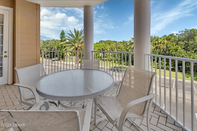 a view of a balcony with chairs and potted plants