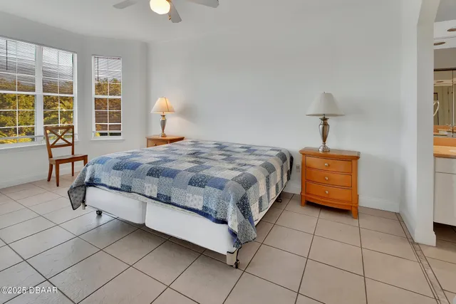 a bedroom with a bed and a lamp on table chair
