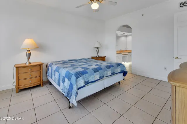 a bedroom with a bed and large windows