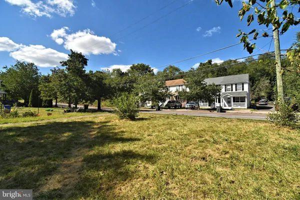 a house view with swimming pool and trees in the background