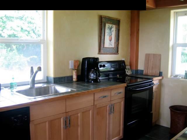 438 Kaupakalua Road Haiku, HI 96708 - Photo 5 of 18 a kitchen with granite countertop a sink stove and cabinets