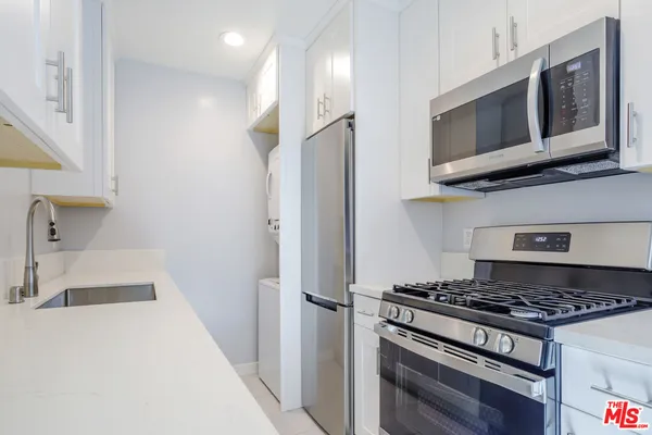 a kitchen with stainless steel appliances granite countertop a stove and a refrigerator